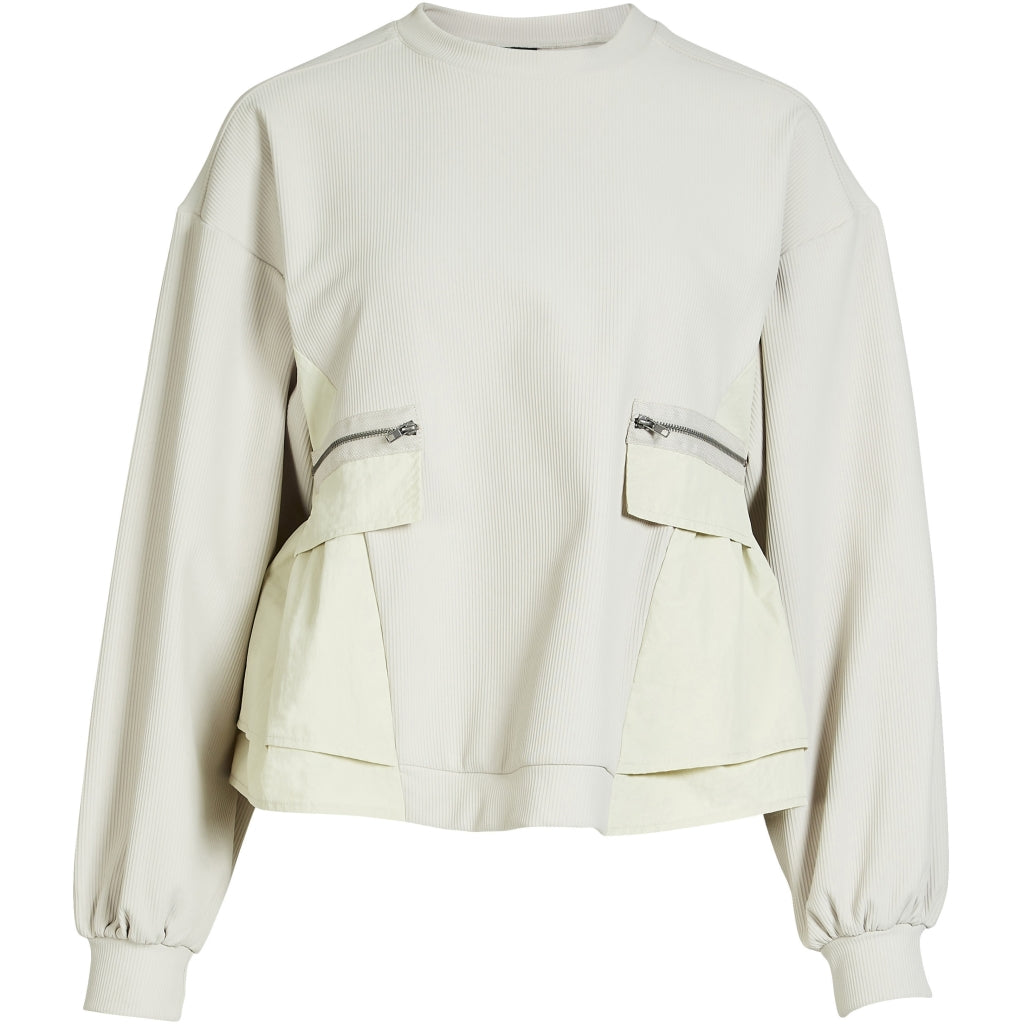 langærmet hvid bluse med ribbet struktur, sænkede skuldre lynlåslommer foran og en let markeret talje. NÜ Zinne Blouse Bone