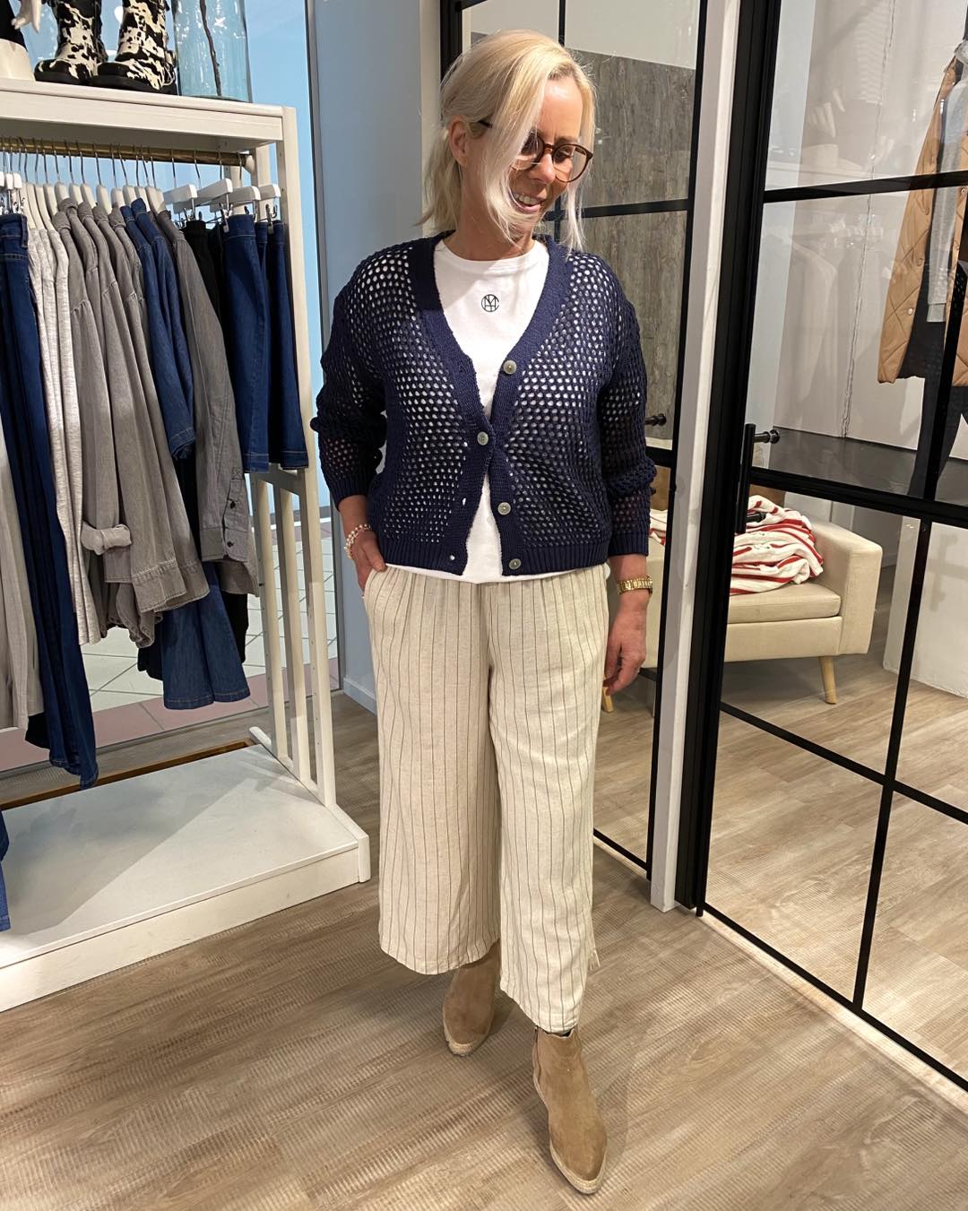 Lene med blå cardigan og stribet beige bukser