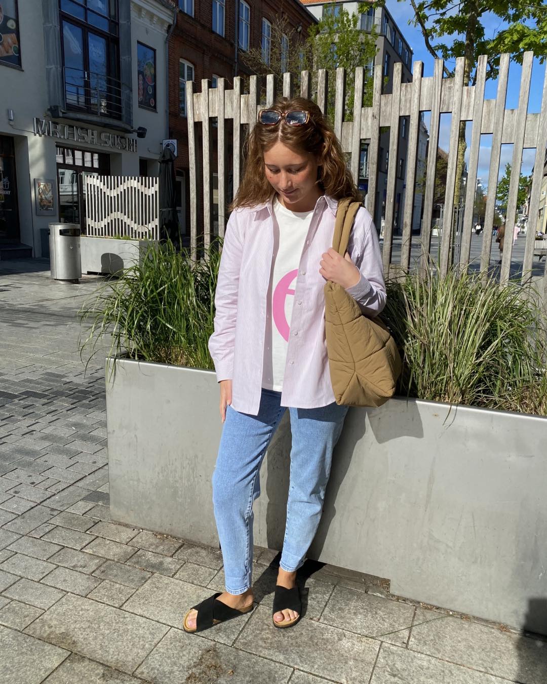 Luna i lyserød stribet skjorte åben over en t-shirt til et par jeans