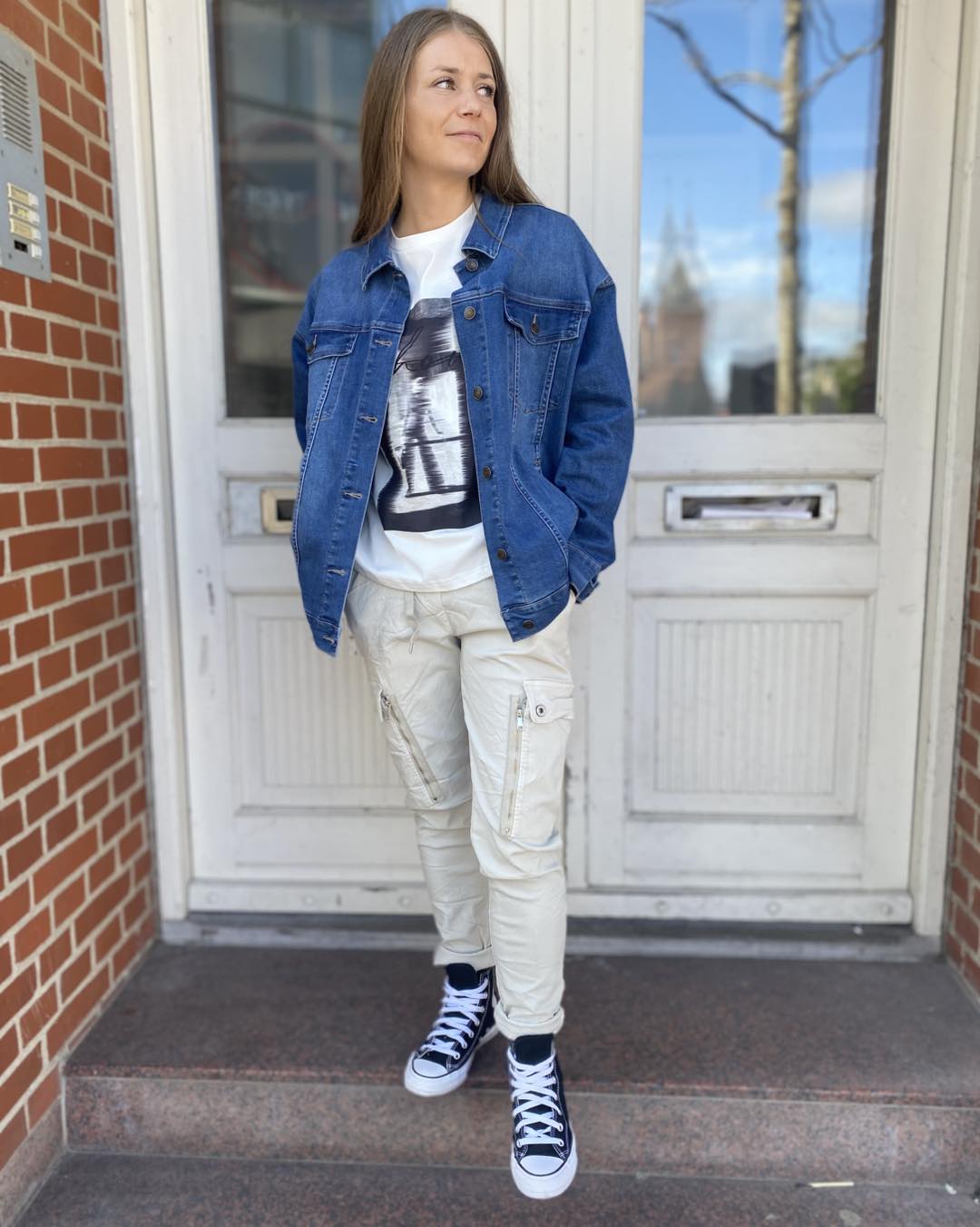 Marie med denimjakke, t-shirt med print og hvide bukser