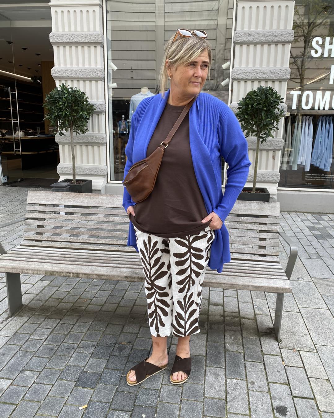 janni med blå cardigan over bluse til mønstret bukser med palmeblade