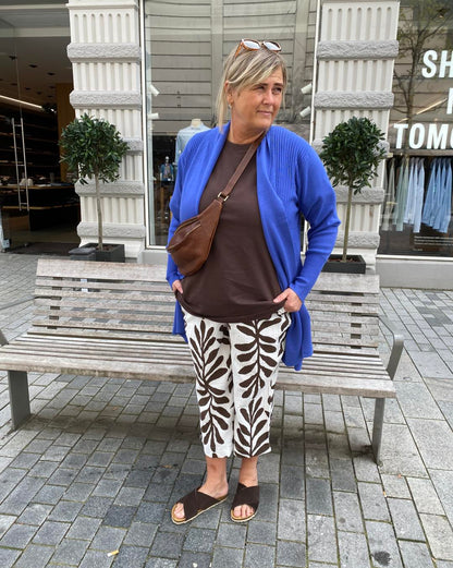 janni med blå cardigan over bluse til mønstret bukser med palmeblade