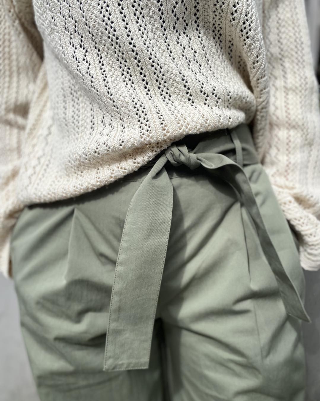 closeup af cremefarvet hvid strik og grønne bukser