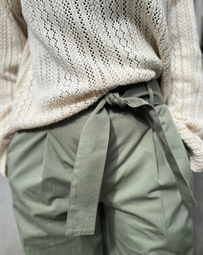 closeup af cremefarvet hvid strik og grønne bukser