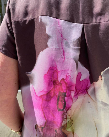 closeup af ryggen på mønstret kjole i røde nuancer fra Nü