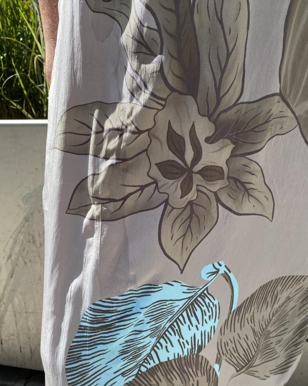 closeup af blomstermønster på kjole i grå og blå med korte ærmer