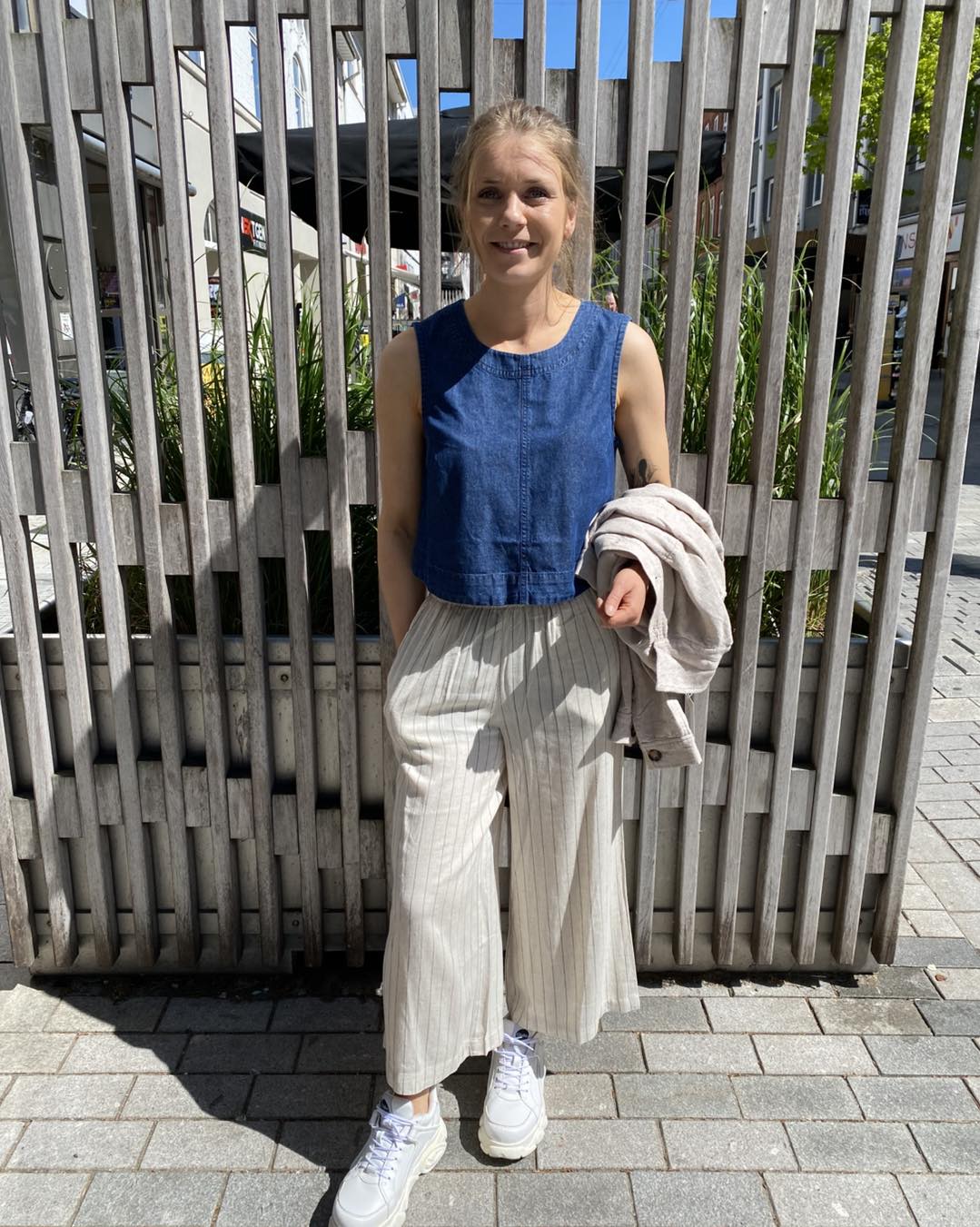 Maire med blå top i denim og beige bukser