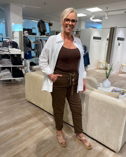 Lene med brun top, hvid åben skjorte og brune joggingbukser fra mind by lene