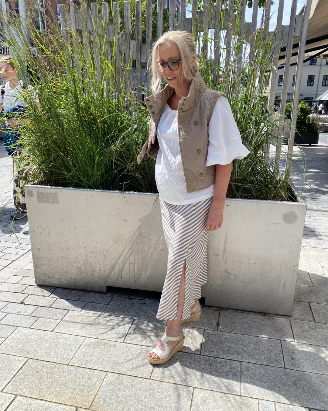 lene med lang nederdel, hvid bluse og beige vest