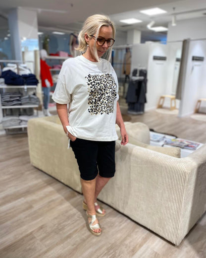 lene med hvid t-shirt med print foran og sorte shorts