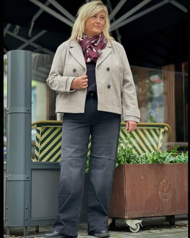 janni med sorte jeans og lys beige kort jakke