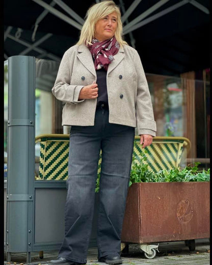 janni med sorte jeans og lys beige kort jakke