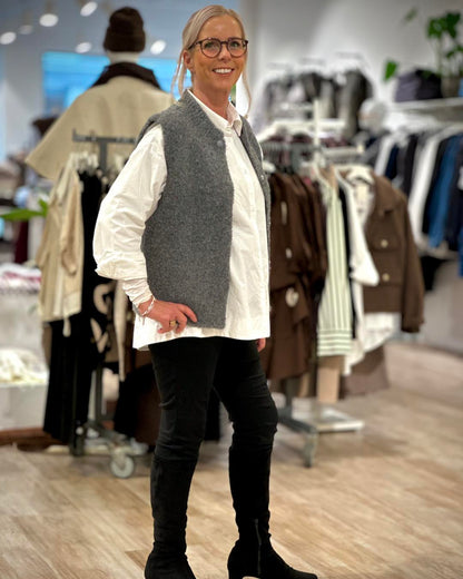 lene med hvid skjorte og grå strik vest