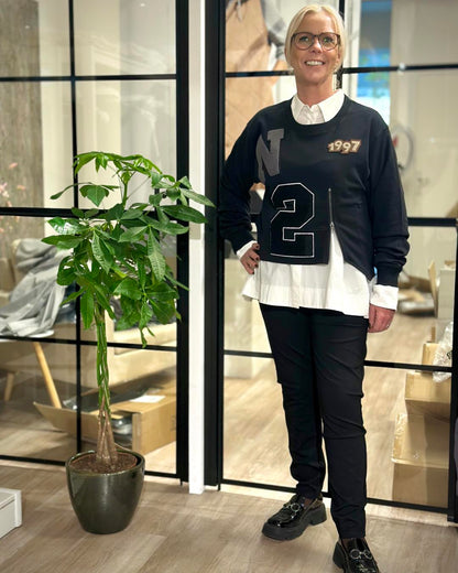 lene med sort sweatshirt over hvid skjorte