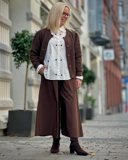 Lene med brun cardigan, hvid skjorte med hjerter og brune bukser