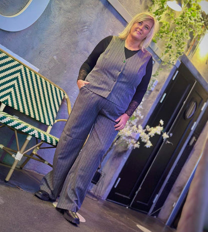 Janni med grå vest og bukser med små sten. ONLY Carmakoma CARSIGA