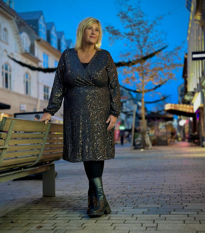 Janni med glitrende kjole i sølv med lange ærmer