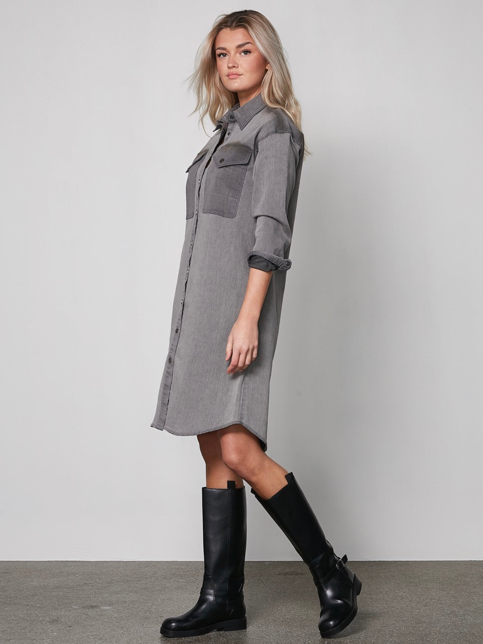 model med grå kjole med denim-llok, lange ærmer, knappelukning og to store brystlommer. NÜ Yelena Dress Grey 8300-23