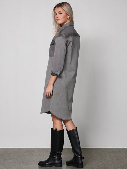 model fra siden med grå kjole med denim-llok, lange ærmer, knappelukning og to store brystlommer. NÜ Yelena Dress Grey 8300-23