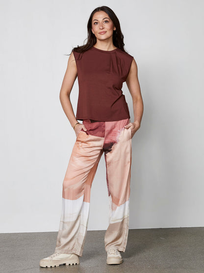 model med mønstrede bukser i røde og lyse nuancer med sidelommer og elastik i taljen. NÜ Elina Yola Trousers Berry Red Mix 8306-10