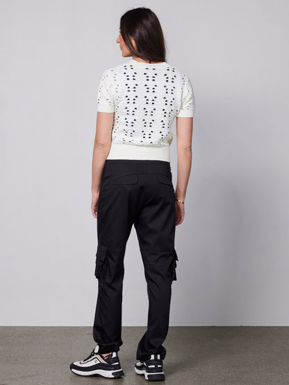 ryggen af model med kortærmet strikket hvid t-shirt med hullet mønster og v-hals. NÜ Yaffa Blouse Creme 8334-50