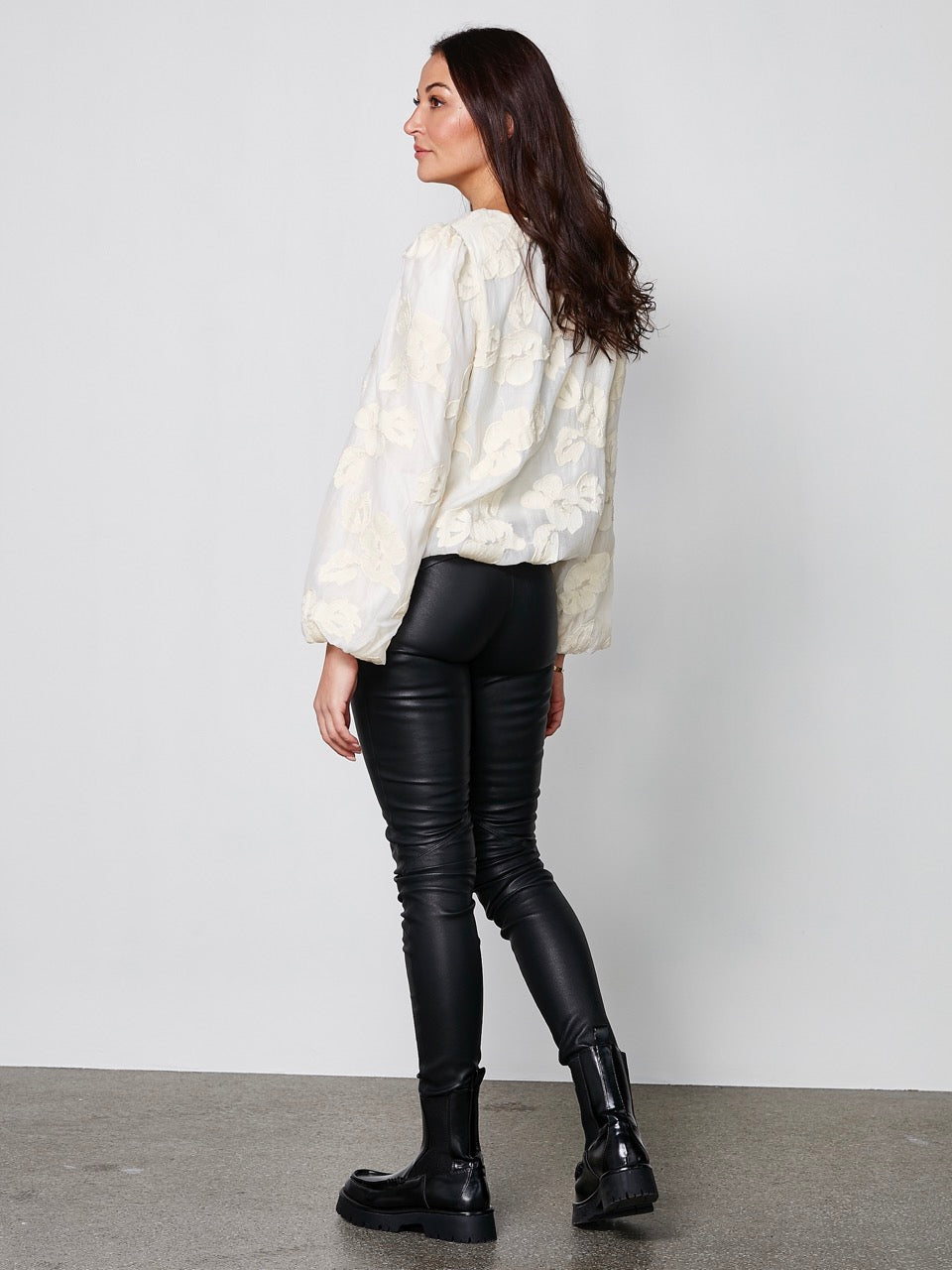 model fra siden med langærmet hvid bluse med rund hals, broderet blomsterdetaljer og ballonærmer. NÜ Yan Blouse creme 8353-50