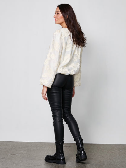 model fra siden med langærmet hvid bluse med rund hals, broderet blomsterdetaljer og ballonærmer. NÜ Yan Blouse creme 8353-50