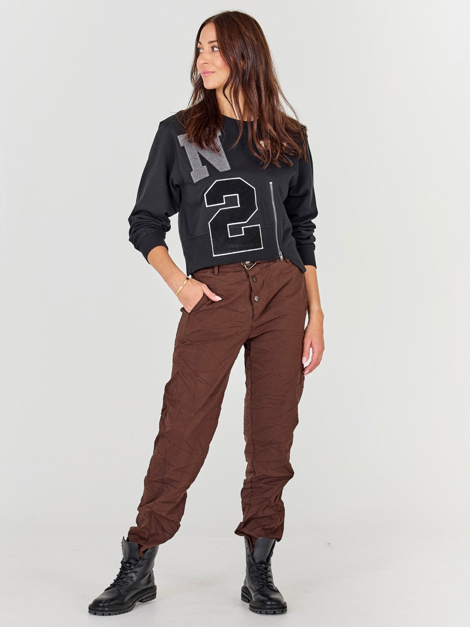 model med brune bukser og sort sweatshirt med lynlås og broderi. NÜ Asis Sweat Black