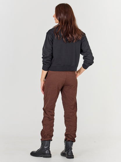 ryggen af model med sort sweatshirt med lynlås og broderi. NÜ Asis Sweat Black