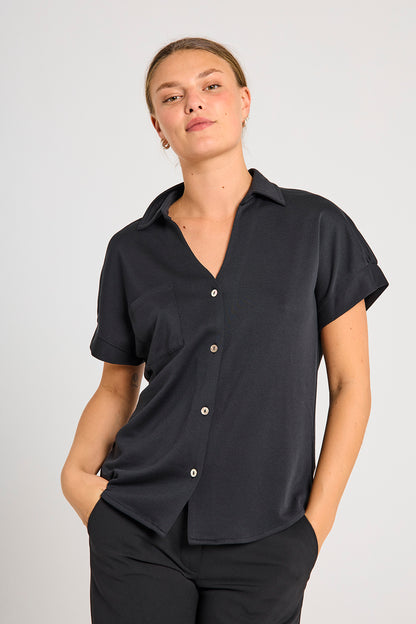 model med kortærmet sort skjorte t-shirt med knappelukning og brystlomme. Freequent Black FQRUE-BLOUSE