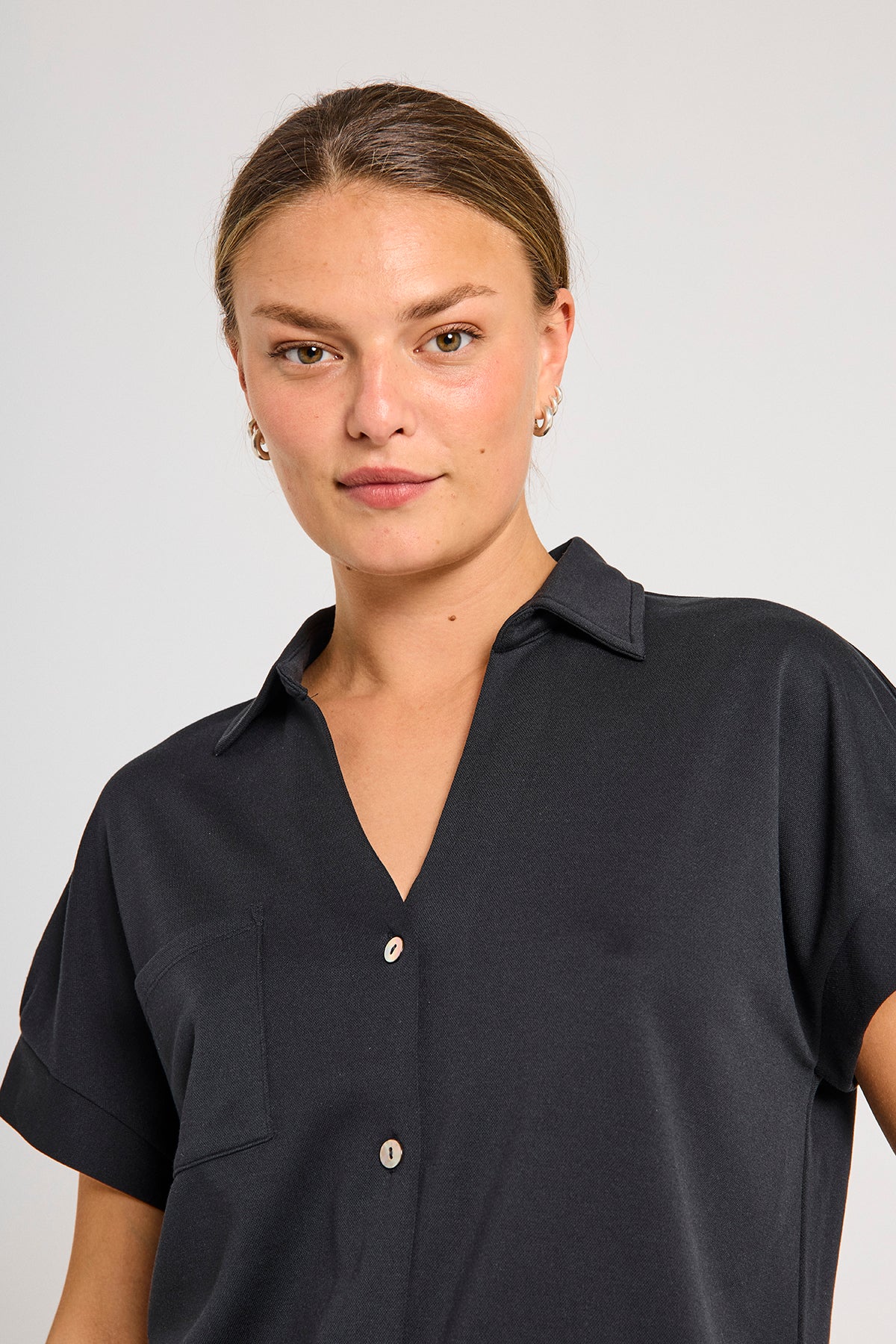 closeup af krave på kortærmet sort skjorte t-shirt med knappelukning og brystlomme. Freequent Black FQRUE-BLOUSE