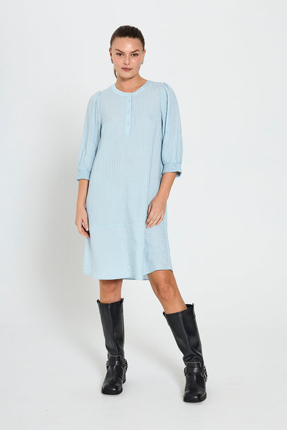 model med støvler og blå kjole med 3/4 pufærmer, knaplukning foran og en let struktur. Freequent FQABY-DRESS Chambray Blue