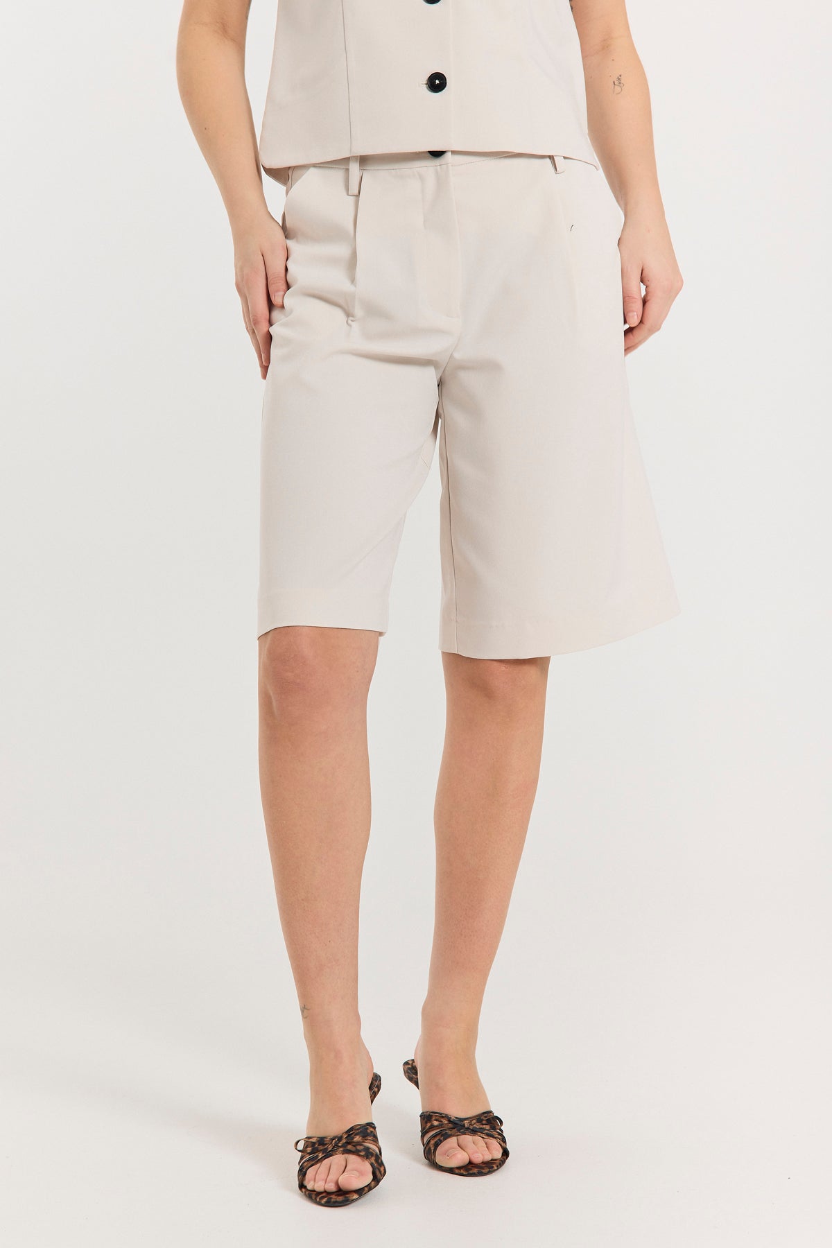 nærbillede af model med lange beige shorts med sidelommer og knap/lynlåslukning. Freequent FQMAEVE-SHORTS Moonbeam