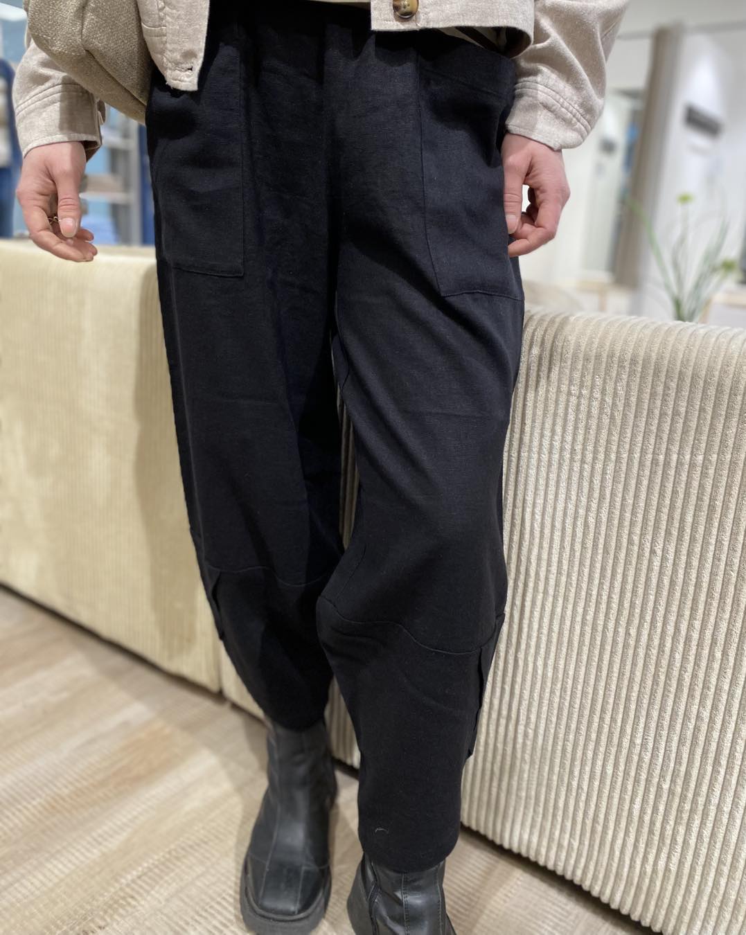 sorte bukser med bukseben der har et asymmetrisk snit