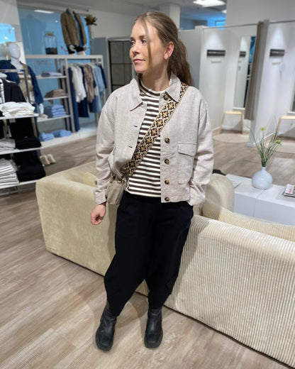 model med sorte bukser med bukseben der har et asymmetrisk snit