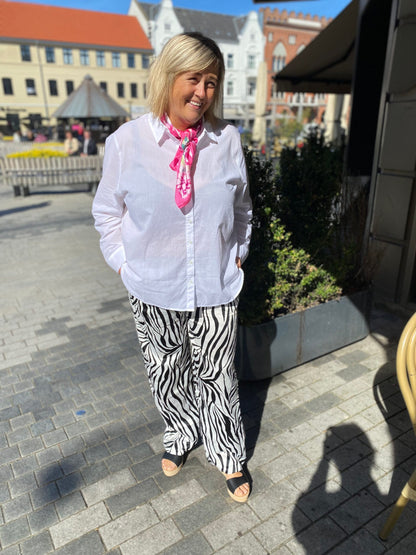 janni med en hvis skjorte og bukser med zebraprint. ONLY Carmakoma CARYAVA Straight Pants Zebra