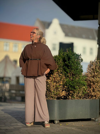 Lene med brun poncho og brune ternede bukser