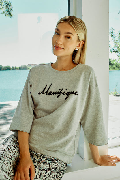 model med grå t-shirt med sænkede skuldre og sort tekst på brystet. Freequent Light Grey Black FQKASSY-PULLOVER