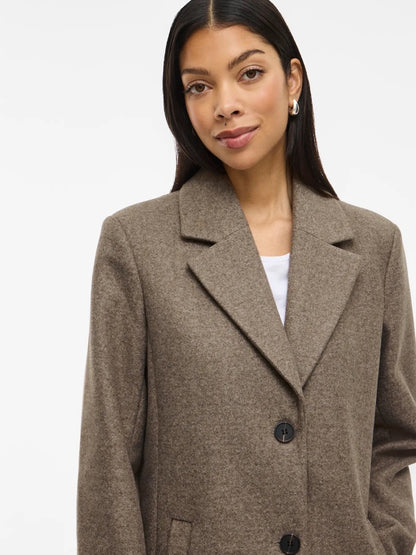 krave på lys brun frakke med krave og dobbelt knaplukning. VILA VICLAUDIA Button Coat Falcon Melange