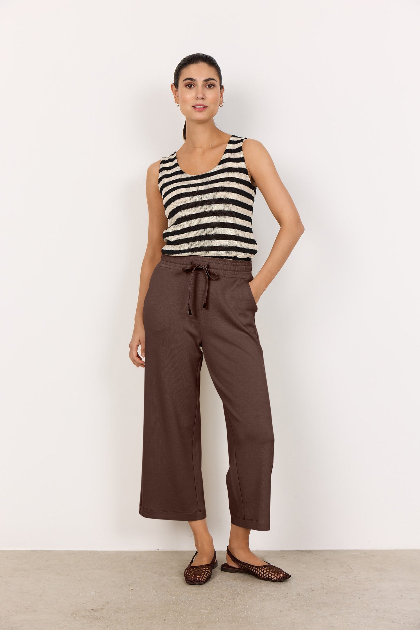 model med hånden i lommen på brune joggingbukser med snøre i taljen og sidelommer. Soyaconcept SC-BANU 26 Bukser HOT FUDGE