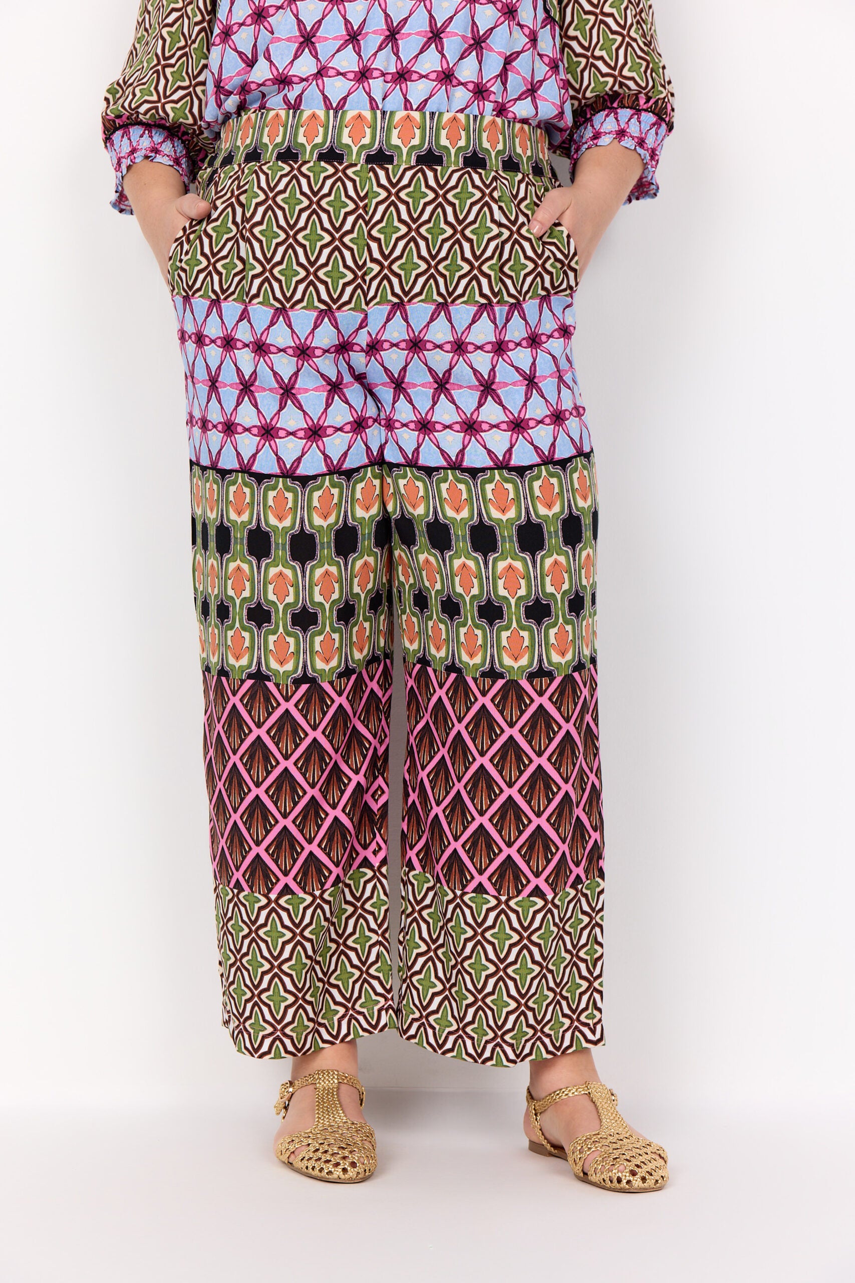 nærbillede af model med mønstret bukser i mange farver. Wasabi WA-MELIKA 2 Bukser Wild Rose Combi