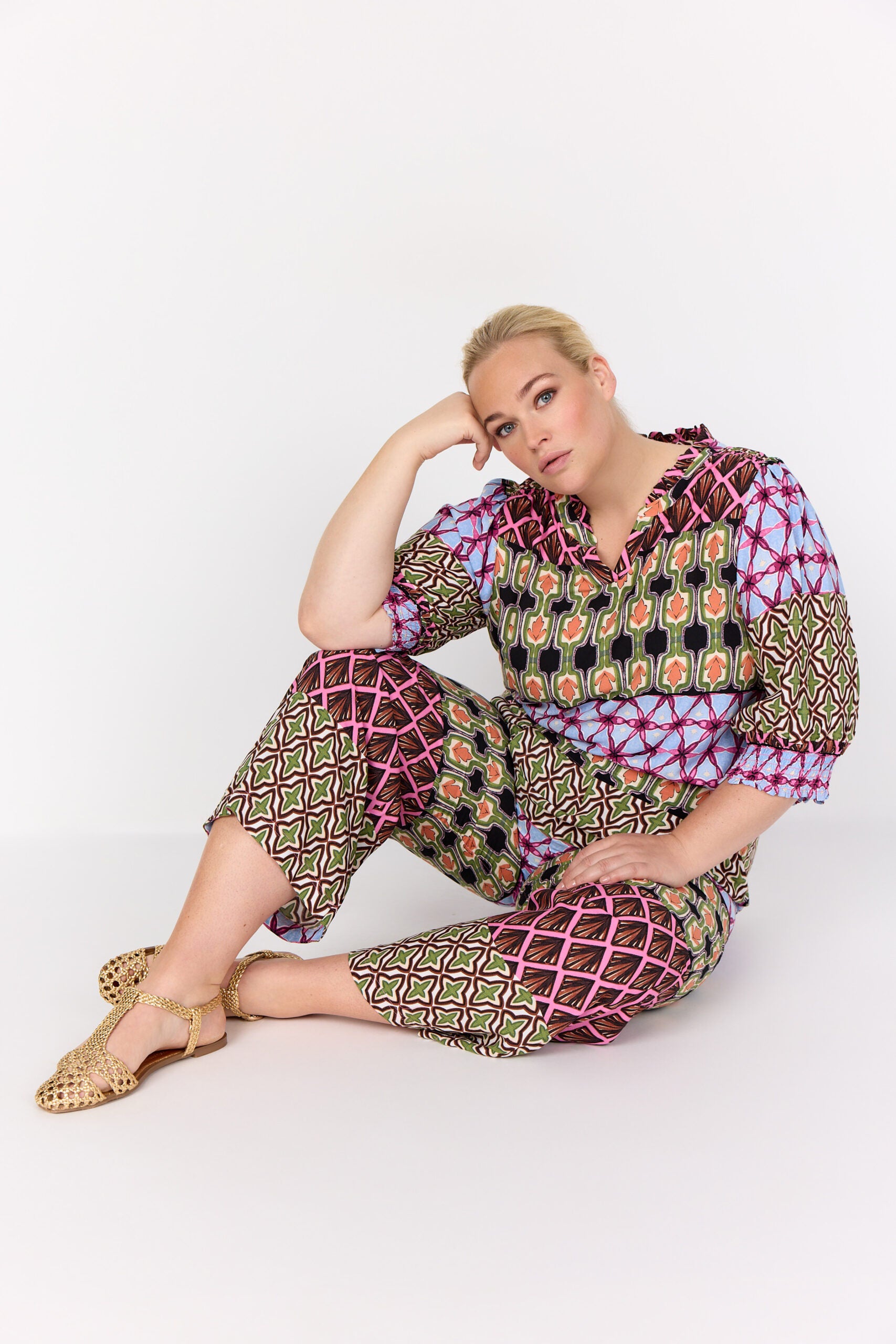 model siddende med mønstret bukser i mange farver. Wasabi WA-MELIKA 2 Bukser Wild Rose Combi