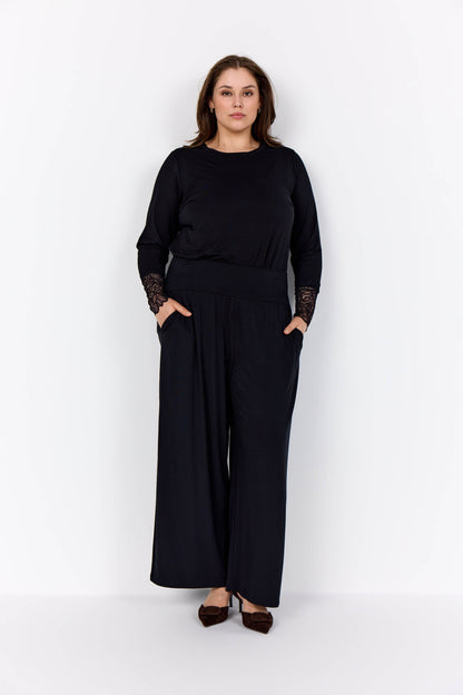 model med sorte bukser og langærmet sort bluse med blonder på ærmerne. Wasabi WA-STELLA 24 Bluse Black