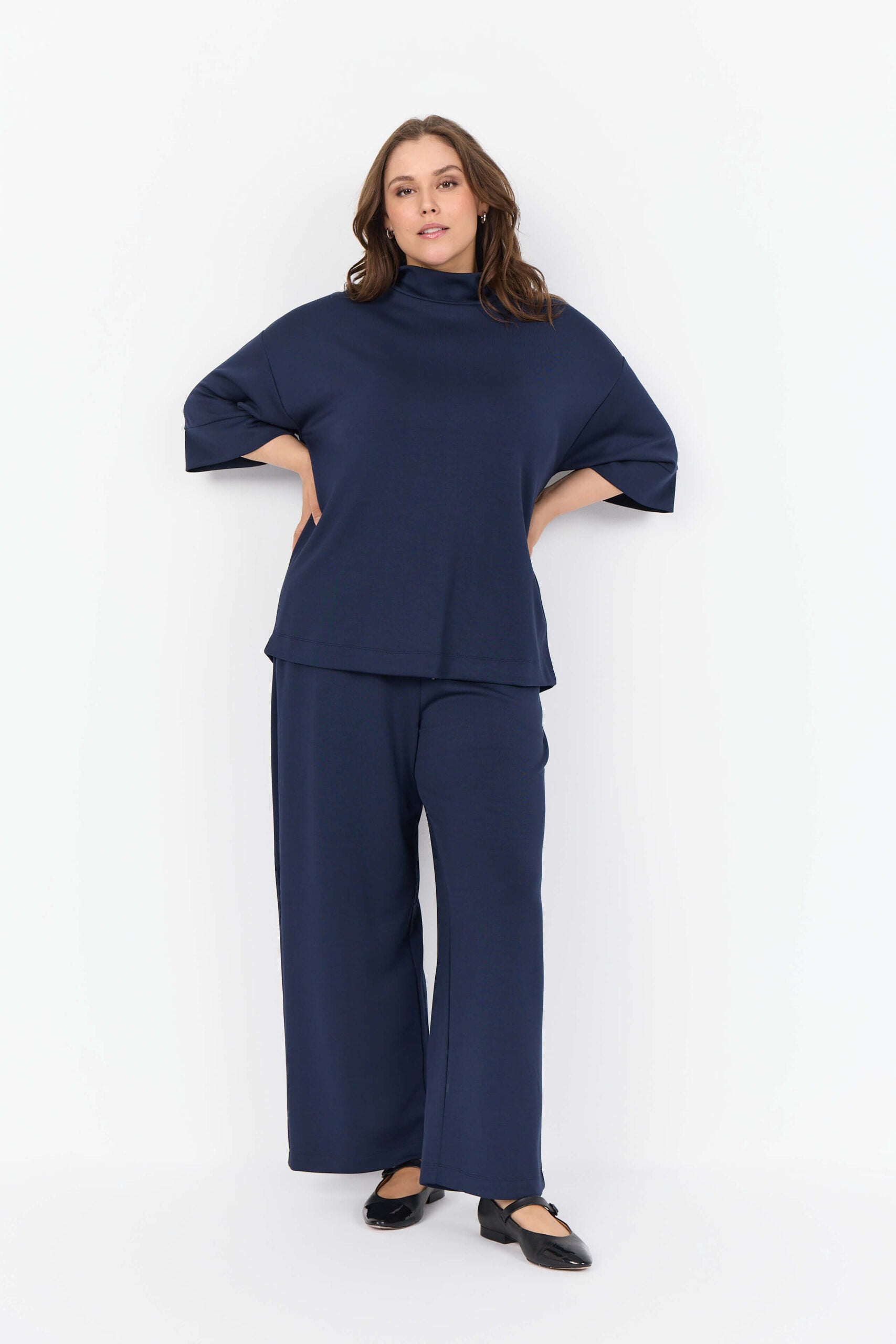 model med blå bukser og afslappet blå bluse med høj hals og bred pasform. Wasabi WA-SABINA 64 Bluse Navy Blazer