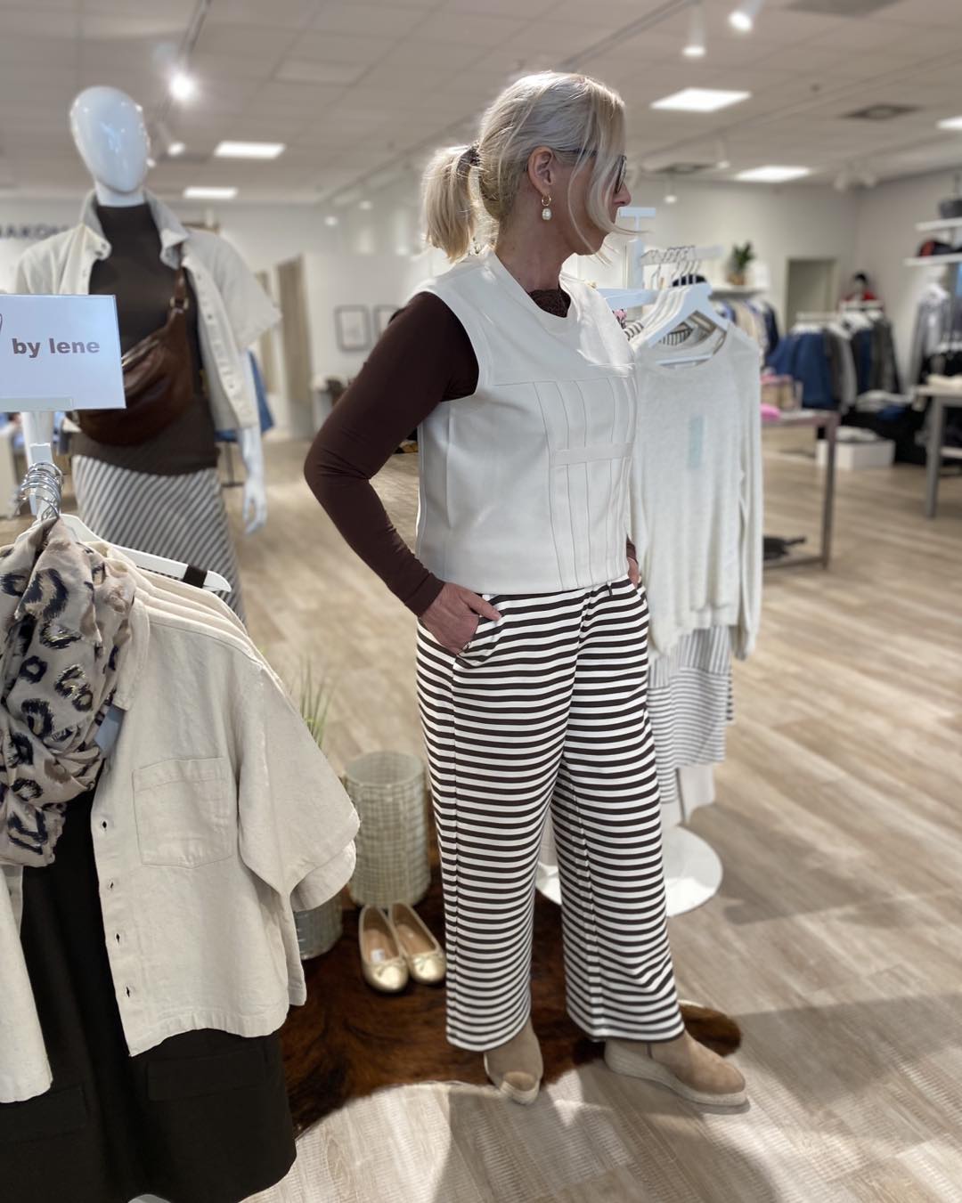 lene med en langærmet brun t-shirt med en hvid top over til et par stribet bukser