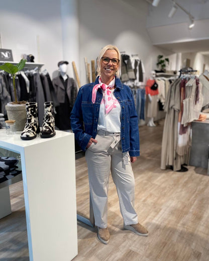 lene med denimjakke og beige bukser med bælte i taljen