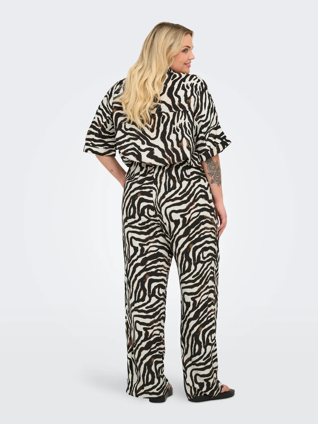 ryggen af model med bukser med zebra print. ONLY Carmakoma CARBERTE Pants Pumice Stone Zebra