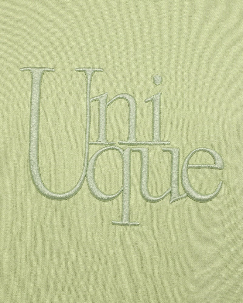 closeup af broderi på limegrøn sweatshirt med slids i sidesømmen. Freequent Shadow Lime FQPROSIT-PULLOVER