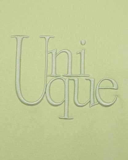 closeup af broderi på limegrøn sweatshirt med slids i sidesømmen. Freequent Shadow Lime FQPROSIT-PULLOVER