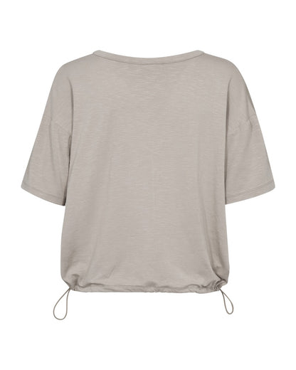 ryggen af kortærmet beige bluse med justerbar snøre i bunden